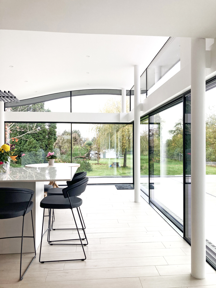 Modern extension with opening corner sliding doors by Ultraline and curved glass
